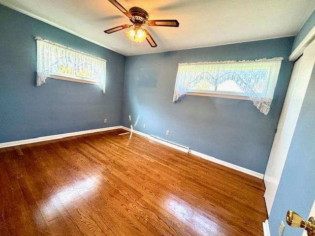 1710 N 25th St, Sheboygan, WI 53081 - unfurnished room featuring a ceiling fan, wood finished floors, and baseboard heating