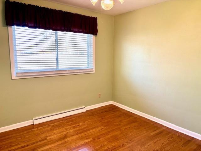 1710 N 25th St, Sheboygan, WI 53081 - empty room featuring a baseboard heating unit, wood finished floors, and a ceiling fan