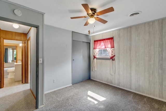 226 Winnebago Ave, Portage, WI 53901 - unfurnished bedroom with carpet, wooden walls, a closet, and a ceiling fan