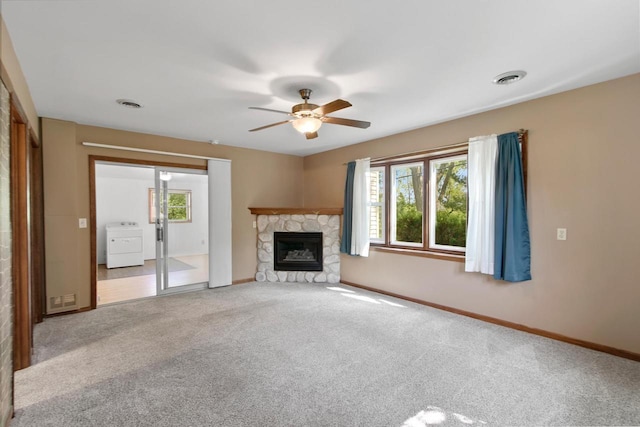 226 Winnebago Ave, Portage, WI 53901 - unfurnished living room featuring washer / dryer, ceiling fan, carpet floors, and a stone fireplace
