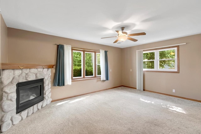 226 Winnebago Ave, Portage, WI 53901 - unfurnished living room with carpet floors, a stone fireplace, and a ceiling fan