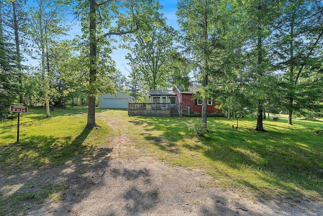N11134 Nelson Rd, Athelstane, WI 54104 - view of green lawn with driveway, an outdoor structure, a deck, and a detached garage