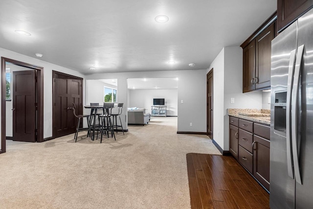 6600 N Kurey Dr, Appleton, WI 54913 - kitchen with stainless steel refrigerator with ice dispenser, dark brown cabinets, light stone countertops, open floor plan, and carpet floors