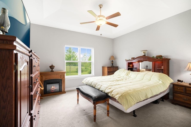 2701 Esker Dr, West Bend, WI 53095 - bedroom featuring light carpet, a glass covered fireplace, and a ceiling fan