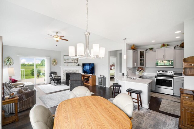 2701 Esker Dr, West Bend, WI 53095 - dining area featuring ceiling fan, a fireplace, vaulted ceiling, dark wood-type flooring, and recessed lighting