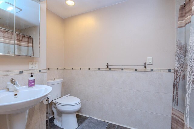 1340 Deer Brook Ct, Wausau, WI 54401 - bathroom with tile walls, wainscoting, and a shower with shower curtain