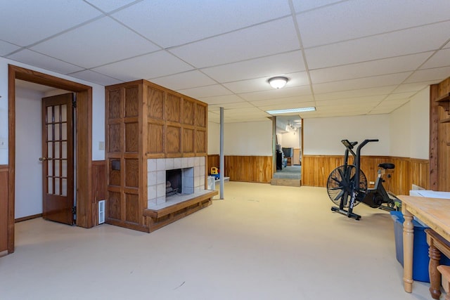 1340 Deer Brook Ct, Wausau, WI 54401 - exercise room with wooden walls, a fireplace with raised hearth, wainscoting, and a drop ceiling