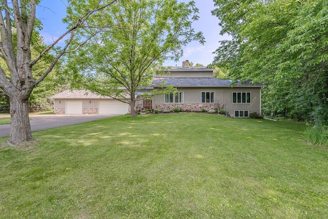 1340 Deer Brook Ct, Wausau, WI 54401 - view of front facade with a garage, a chimney, driveway, a front lawn, and stone siding