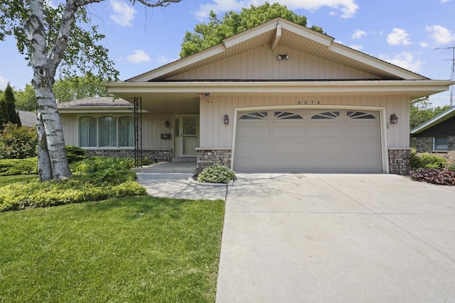 8074 48th Ave, Kenosha, WI 53142 - view of front facade featuring concrete driveway, a garage, a front yard, and stone siding