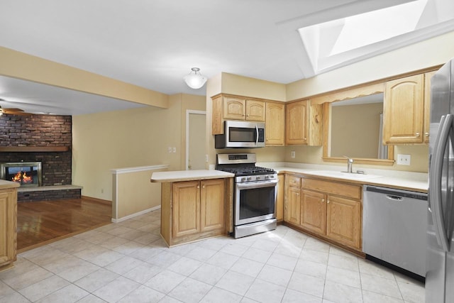 8074 48th Ave, Kenosha, WI 53142 - kitchen featuring appliances with stainless steel finishes, light countertops, a skylight, open floor plan, and a fireplace