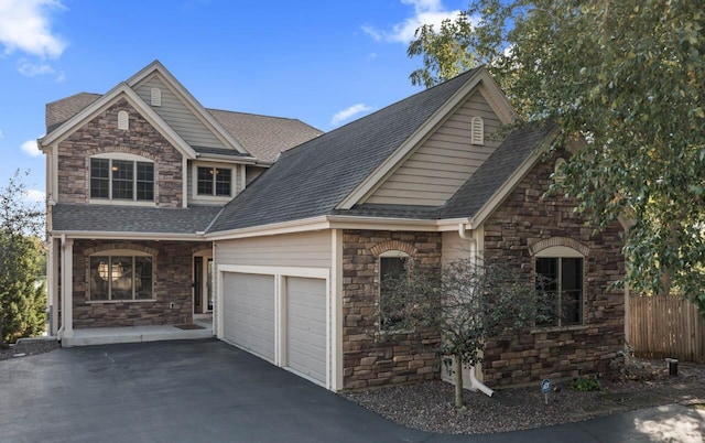 6507 Willow Ct, Waterford, WI 53185 - view of front of property featuring stone siding, a garage, driveway, and roof with shingles