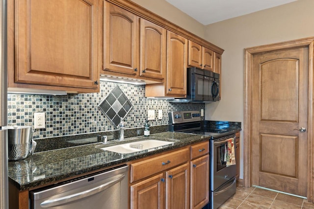6507 Willow Ct, Waterford, WI 53185 - kitchen featuring appliances with stainless steel finishes, tasteful backsplash, brown cabinets, and dark stone counters