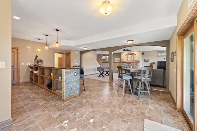 6507 Willow Ct, Waterford, WI 53185 - kitchen featuring arched walkways, dark countertops, a breakfast bar area, open shelves, and ceiling fan