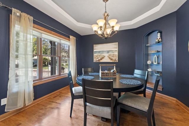 6507 Willow Ct, Waterford, WI 53185 - dining room featuring a chandelier, wood finished floors, and a raised ceiling
