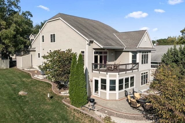 6507 Willow Ct, Waterford, WI 53185 - rear view of house with a shingled roof, a balcony, a lawn, and a patio area