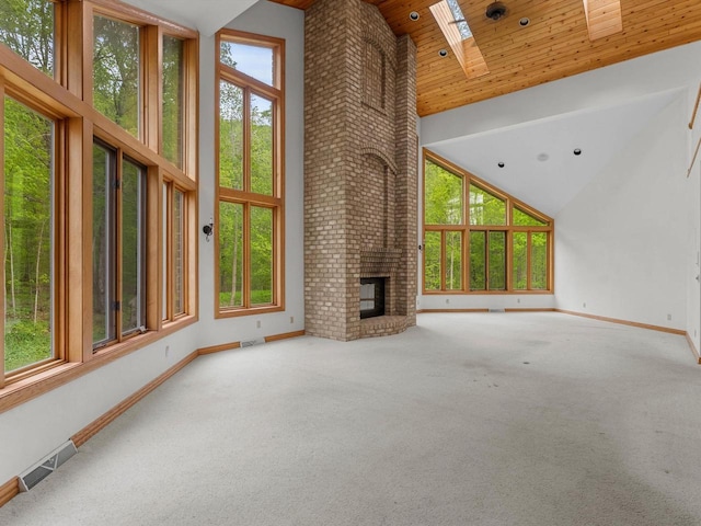4228 County Hwy W, Valders, WI 54245 - unfurnished living room with high vaulted ceiling, wood ceiling, a skylight, carpet flooring, and a brick fireplace