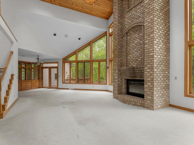 4228 County Hwy W, Valders, WI 54245 - unfurnished living room with high vaulted ceiling, a brick fireplace, stairway, carpet floors, and wooden ceiling