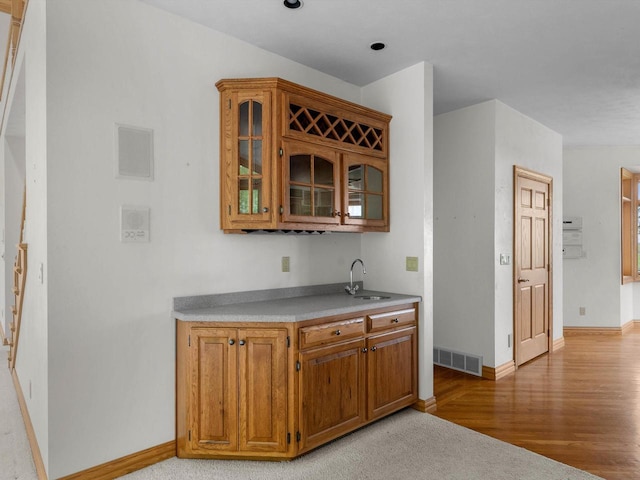 4228 County Hwy W, Valders, WI 54245 - kitchen featuring glass insert cabinets, light wood finished floors, brown cabinetry, and light countertops