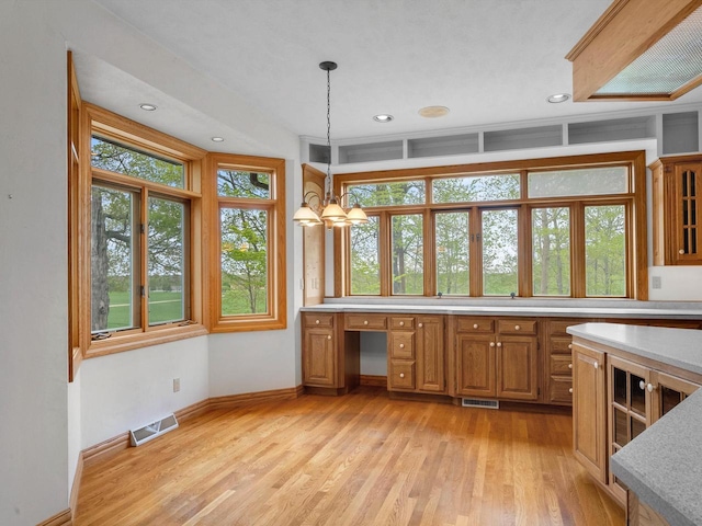 4228 County Hwy W, Valders, WI 54245 - kitchen featuring brown cabinetry, light wood finished floors, light countertops, decorative light fixtures, and an office area