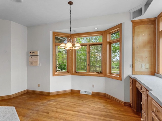 4228 County Hwy W, Valders, WI 54245 - unfurnished dining area featuring light wood-style flooring and a chandelier