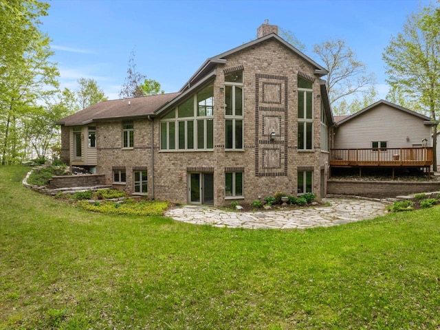 4228 County Hwy W, Valders, WI 54245 - rear view of house featuring brick siding, a wooden deck, a chimney, and a lawn