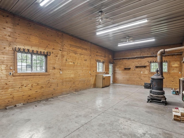 4228 County Hwy W, Valders, WI 54245 - garage with a wood stove, wooden walls, and ceiling fan