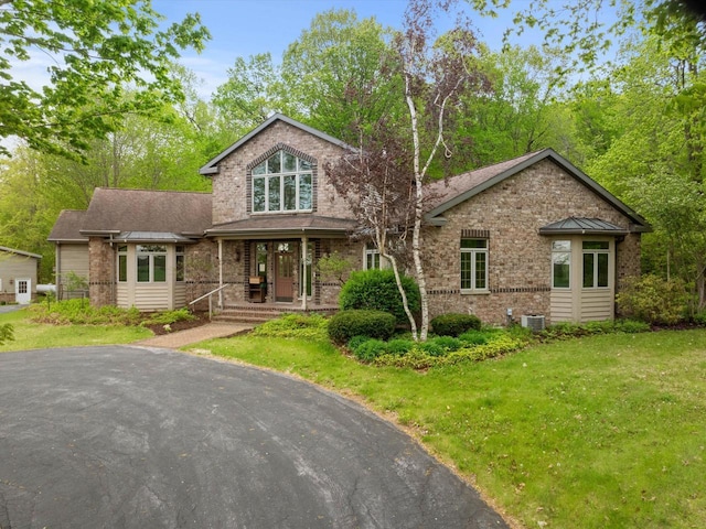 4228 County Hwy W, Valders, WI 54245 - view of front facade featuring a front yard, brick siding, and covered porch