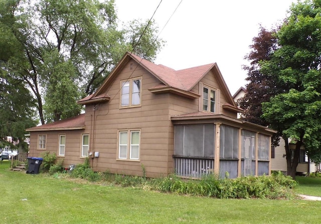 208 S Walker St, Wautoma, WI 54982 - view of side of home with a sunroom, a yard, and a shingled roof