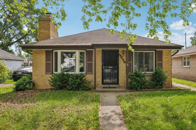 3838 N 78th St, Milwaukee, WI 53222 - view of front of home with brick siding, a chimney, and a front yard