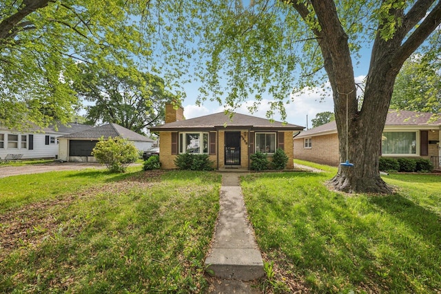 3838 N 78th St, Milwaukee, WI 53222 - bungalow-style house with a chimney, a front lawn, brick siding, and a garage