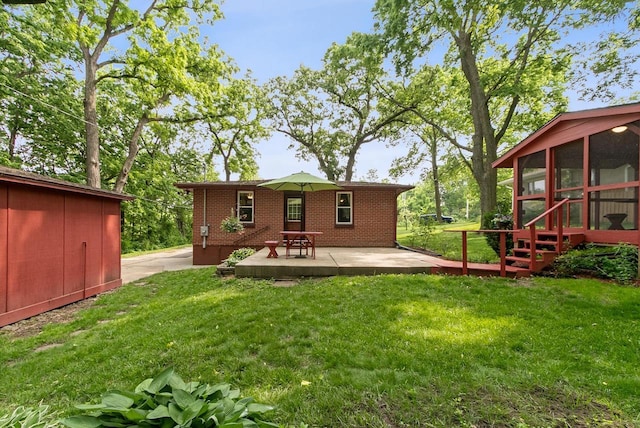 3716 County Rd Unit B, Mcfarland, WI 53558 - back of property with a sunroom, brick siding, a yard, and a patio