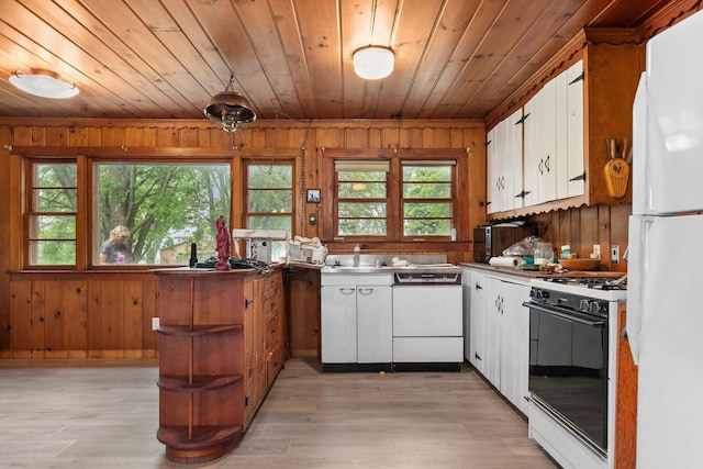 8950 Pine Ln, Fremont, WI 54940 - kitchen with white appliances, wood ceiling, wooden walls, healthy amount of natural light, and white cabinets