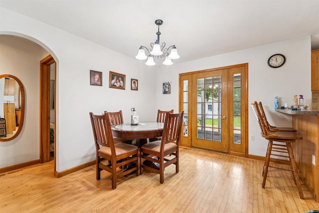 600 Forest Ave, Fond Du Lac, WI 54935 - dining area featuring light wood-type flooring, a chandelier, and arched walkways