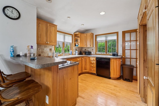600 Forest Ave, Fond Du Lac, WI 54935 - kitchen with black dishwasher, a peninsula, backsplash, light wood finished floors, and a breakfast bar