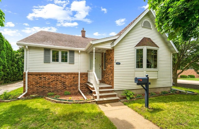600 Forest Ave, Fond Du Lac, WI 54935 - view of front facade featuring a chimney, a front lawn, brick siding, and a shingled roof