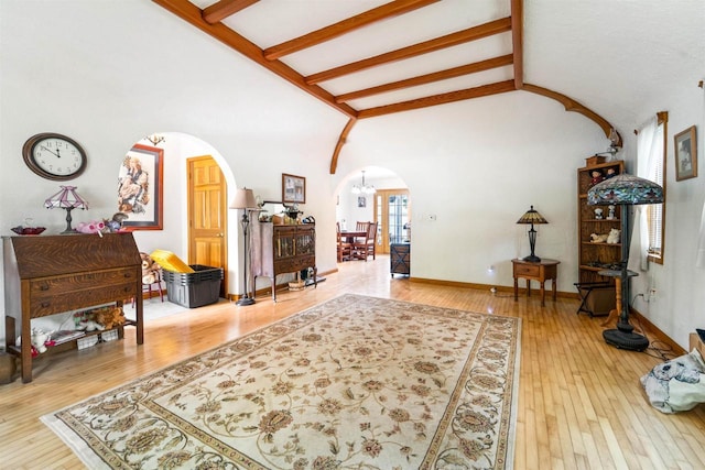 600 Forest Ave, Fond Du Lac, WI 54935 - living area featuring arched walkways, beamed ceiling, light wood-type flooring, high vaulted ceiling, and a chandelier