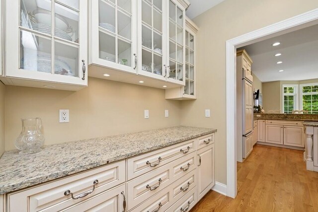 N1760 W Valley Park Rd, Lake Geneva, WI 53147 - kitchen with light wood-style floors, recessed lighting, glass insert cabinets, and light stone counters