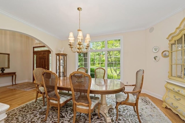 N1760 W Valley Park Rd, Lake Geneva, WI 53147 - dining area featuring arched walkways, a chandelier, ornamental molding, and light wood-style floors