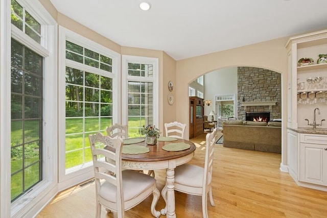 N1760 W Valley Park Rd, Lake Geneva, WI 53147 - dining room with plenty of natural light, light wood-type flooring, a stone fireplace, and arched walkways
