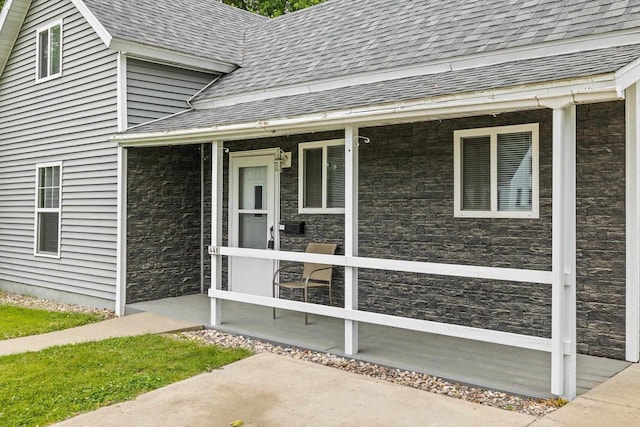 448 Wadleigh St, Stevens Point, WI 54481 - entrance to property featuring a shingled roof, stone siding, and a porch