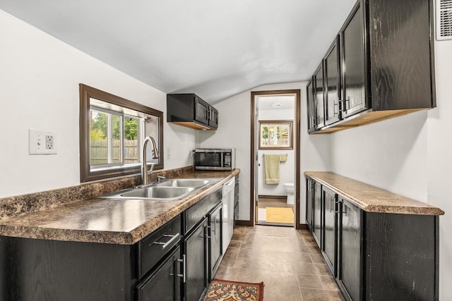 448 Wadleigh St, Stevens Point, WI 54481 - kitchen featuring dark countertops, vaulted ceiling, stainless steel microwave, dark cabinetry, and white dishwasher