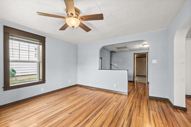 448 Wadleigh St, Stevens Point, WI 54481 - empty room featuring arched walkways, wood finished floors, and ceiling fan