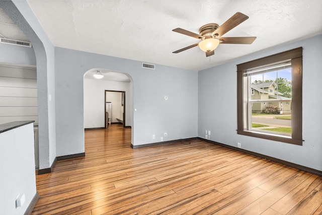 448 Wadleigh St, Stevens Point, WI 54481 - spare room with arched walkways, light wood-style floors, and a ceiling fan