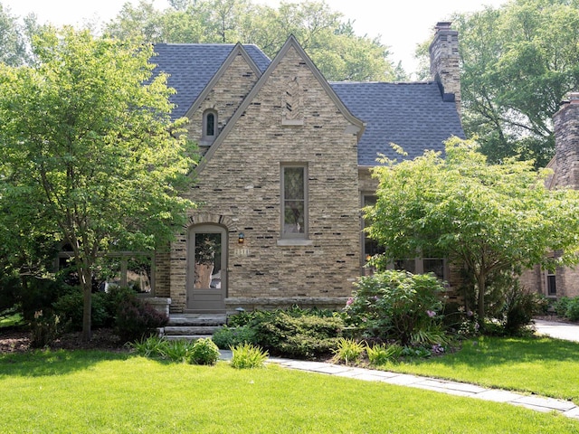 2544 N 91st St, Wauwatosa, WI 53226 - english style home featuring a front yard, a chimney, and brick siding
