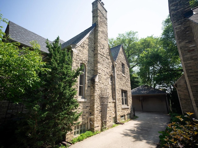 2544 N 91st St, Wauwatosa, WI 53226 - view of home's exterior featuring a garage, a chimney, and an outbuilding