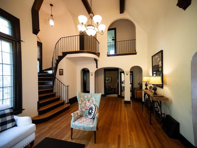2544 N 91st St, Wauwatosa, WI 53226 - living room with high vaulted ceiling, arched walkways, stairs, a chandelier, and wood finished floors