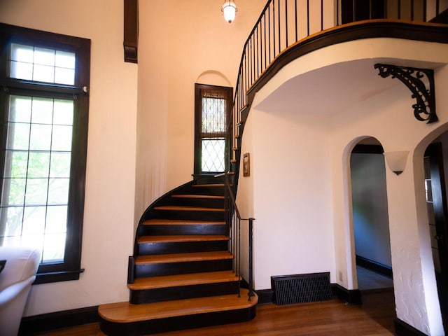 2544 N 91st St, Wauwatosa, WI 53226 - stairs with arched walkways, healthy amount of natural light, a high ceiling, and wood finished floors