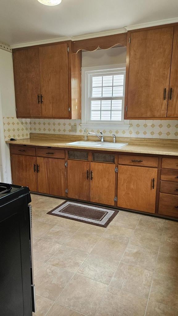1518 Lathrop Ave, Racine, WI 53405 - kitchen featuring black range with electric cooktop, backsplash, light countertops, and brown cabinets