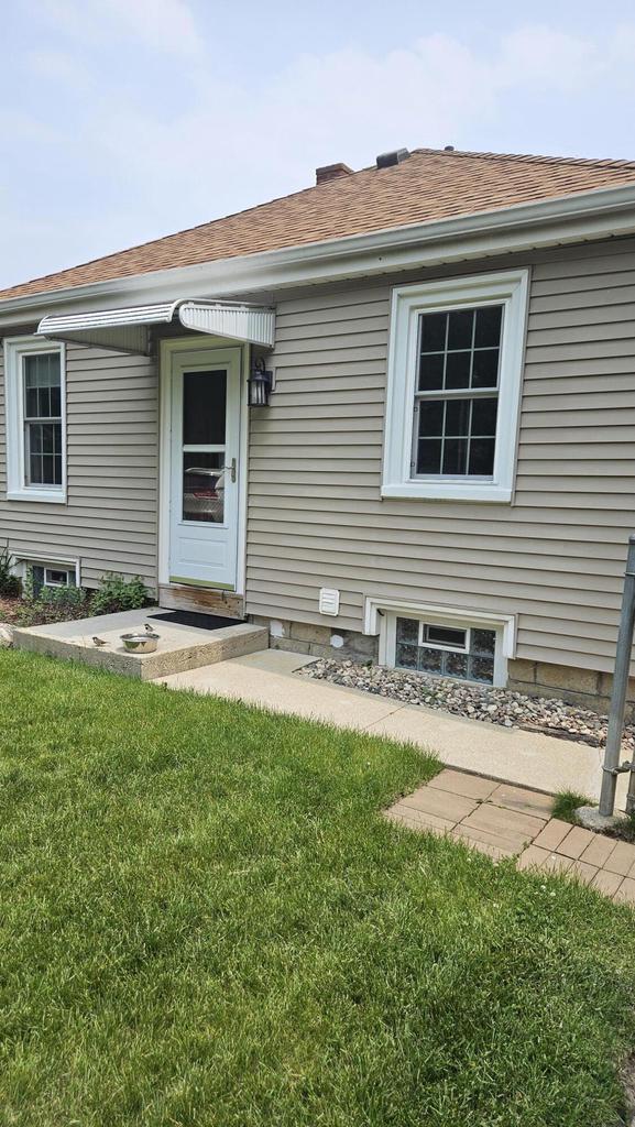 1518 Lathrop Ave, Racine, WI 53405 - view of front of house with a front lawn and a shingled roof