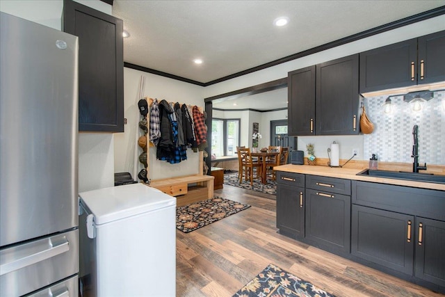 158 S State St, Berlin, WI 54923 - kitchen featuring freestanding refrigerator, ornamental molding, fridge, light wood-style flooring, and light countertops